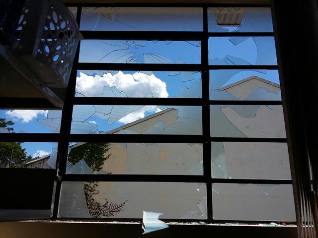 Janelas quebradas por pedras na biblioteca.